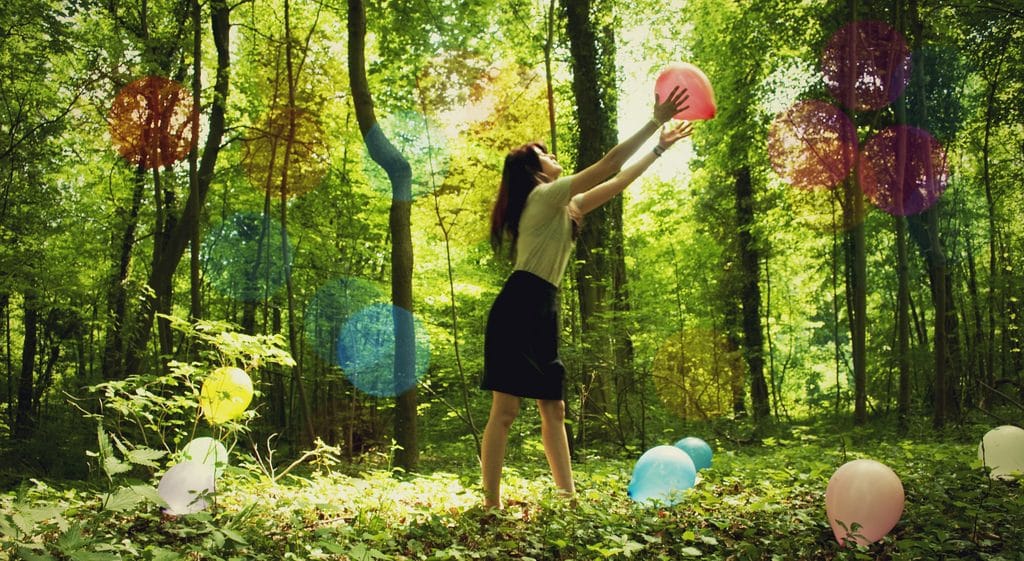 Woman with balloons in a forrest