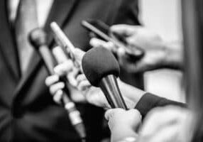 Media Interview - journalists with microphones interviewing formal dressed politician or businessman.